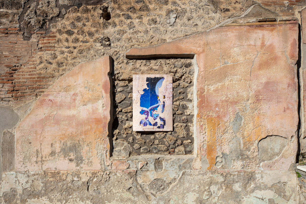 Allison Katz, Pompeii Circumstance (Milk glass), 2023, artist's poster shot in situ at the Archaeological Park of Pompeii, January 2023, Photo Amedeo Benestante. Courtesy the Artist and the Archaeological Park of Pompeii