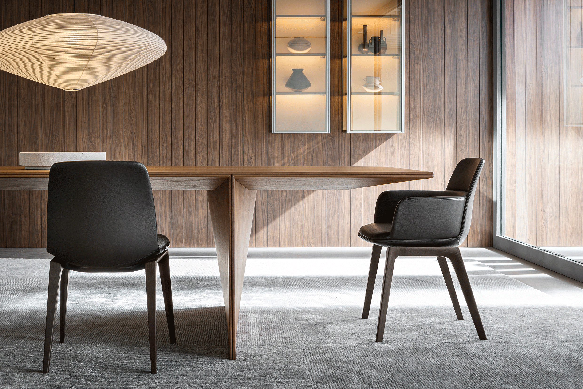wooden table detail with black leather chairs