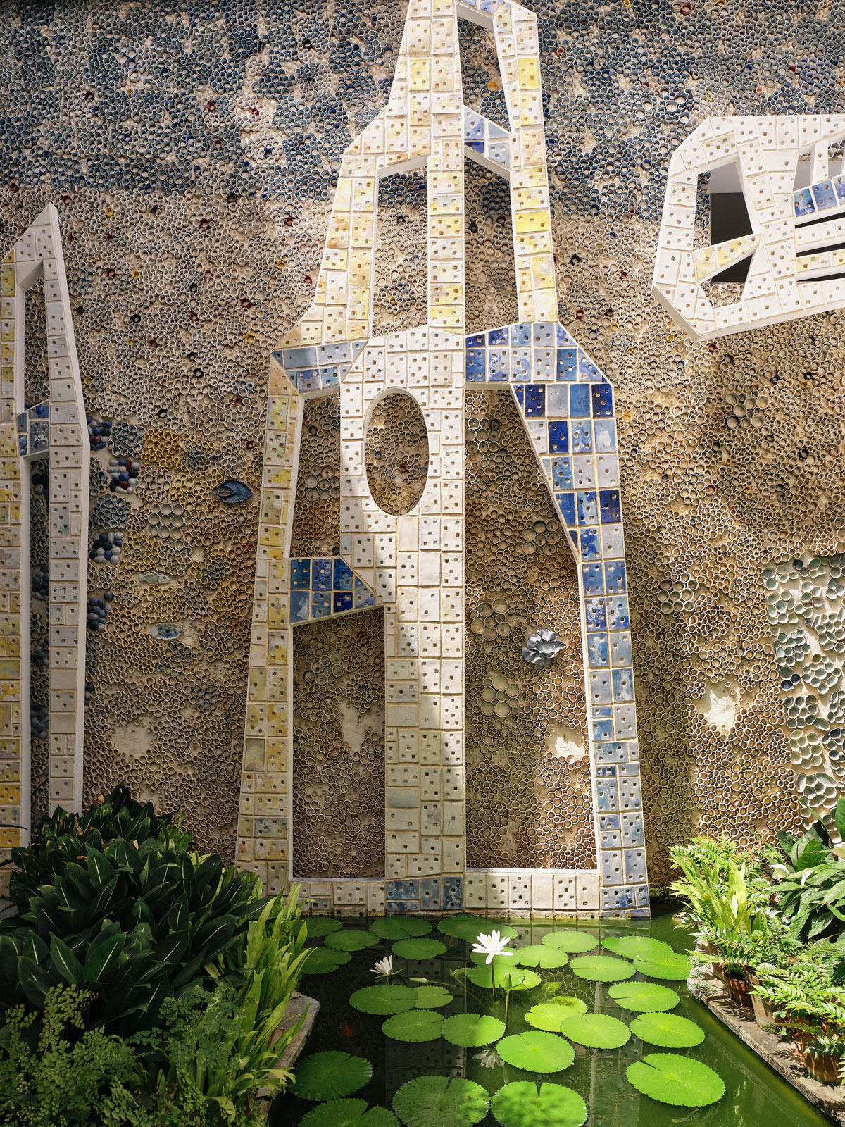 The atrium connects with an outdoor living room full of colors and texture, dominated by a ceramic mosaic by sculptor Fausto Melotti